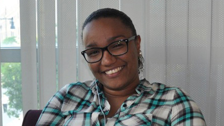 Person smiling with blinds in background.