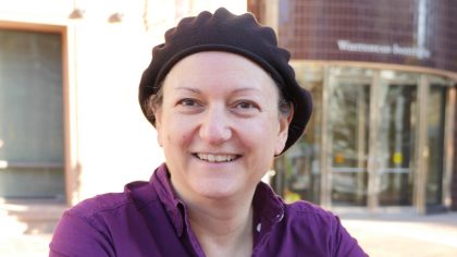 Person with purple shirt and hat