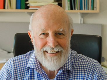 Person with white beard in office