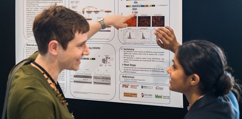 Professor and student pointing at scientific poster