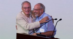 Two people embrace at a podium.
