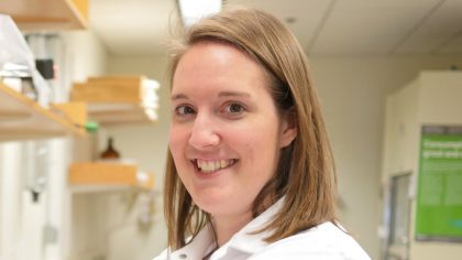Person smiling in lab coat