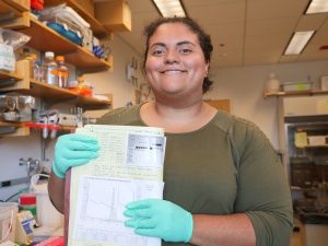 Person smiling with lab notebook