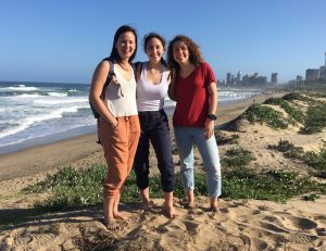 Three people standing on the beach