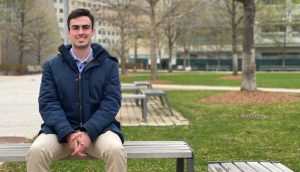 Man smiling on a bench outside