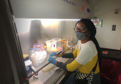 Woman with mask at lab hood