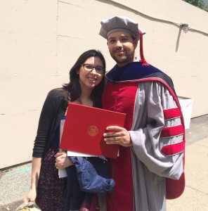 Jose in a graduation cap and gown with Nelly